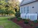 Landscaped backyard with a patio area featuring well-manicured bushes, mulch, and decorative flowers at 531 Grant Rd, Brooks, GA 30205