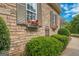 Home's exterior showcasing stone accents, manicured bushes, and window boxes filled with colorful flowers at 531 Grant Rd, Brooks, GA 30205