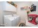 Bright laundry room with white cabinets, washer, dryer, and countertops at 531 Grant Rd, Brooks, GA 30205