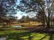 Expansive backyard featuring a tranquil pond surrounded by lush greenery and mature trees in a serene setting at 531 Grant Rd, Brooks, GA 30205