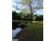 Picturesque view of a serene pond surrounded by lush greenery, mature trees, and manicured lawn at 531 Grant Rd, Brooks, GA 30205