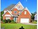 Charming two-story brick home with a well-manicured lawn and bright blue trim around the front door and garage at 3932 Misty Lake, Ellenwood, GA 30294