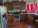 A functional kitchen boasts stainless steel appliances, wooden cabinetry and hardwood floors offering a practical cooking space at 3932 Misty Lake, Ellenwood, GA 30294