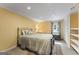 Bedroom featuring tan walls, carpeted floors, a window, and a wrought iron bed frame at 2545 Rockbridge Nw Rd, Conyers, GA 30012