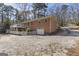 Back exterior of a brick home with a white garage door, wooden deck, and large driveway at 2545 Rockbridge Nw Rd, Conyers, GA 30012
