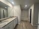 Bright bathroom featuring a double sink vanity with granite countertops, a tub, and plank flooring at 20 Emerald Ln # 1, Covington, GA 30014