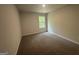 This bedroom has a neutral color palette, plush carpeting, and a bright window with a view at 20 Emerald Ln # 1, Covington, GA 30014