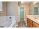 Bright bathroom with a soaking tub, wood-look flooring, and an open doorway to the walk-in closet at 1960 Morning Nw Walk, Acworth, GA 30102