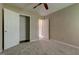 This bedroom has neutral walls, carpet flooring, a ceiling fan, and an open closet at 1960 Morning Nw Walk, Acworth, GA 30102