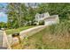 A charming home sits amongst lush trees, showcasing its stone accents and curb appeal at 1960 Morning Nw Walk, Acworth, GA 30102