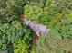 Aerial view of a charming home surrounded by dense trees, with a private driveway and lush landscaping at 9255 Betony Wood Trl, Jonesboro, GA 30236