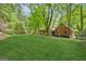 Serene backyard with lush lawn and mature trees surrounding brick home at 9255 Betony Wood Trl, Jonesboro, GA 30236