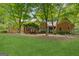 Spacious backyard features a lush lawn, mature trees, and a charming brick home at 9255 Betony Wood Trl, Jonesboro, GA 30236