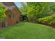 Well-maintained backyard, lush green lawn, and mature trees surround the brick home at 9255 Betony Wood Trl, Jonesboro, GA 30236