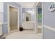 Well lit blue bathroom with a shower, vanity, and large tub at 9255 Betony Wood Trl, Jonesboro, GA 30236
