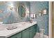 Elegant bathroom featuring a large round mirror and floral wallpaper at 9255 Betony Wood Trl, Jonesboro, GA 30236