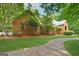 Brick home surrounded by mature trees and landscaping, providing shade and privacy with a curved walkway at 9255 Betony Wood Trl, Jonesboro, GA 30236