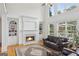 Bright and airy living room featuring a cozy fireplace, built-in bookshelves, and large windows overlooking the outdoor scenery at 1029 Ector Nw Dr, Kennesaw, GA 30152