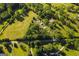 Lovely aerial shot of sprawling acreage reveals verdant pastures, dense trees, and a winding road for a serene landscape at 316 Gaithers Rd, Mansfield, GA 30055