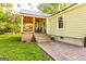 Inviting covered back porch with comfortable seating and an American flag, complemented by a brick patio at 316 Gaithers Rd, Mansfield, GA 30055