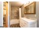 Bathroom showcasing tiled shower/bath, a marble vanity with framed mirror, and wood trim at 316 Gaithers Rd, Mansfield, GA 30055