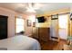 Bright bedroom featuring wood floors, a ceiling fan, a TV, and sliding barn door to closet at 316 Gaithers Rd, Mansfield, GA 30055
