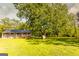 Exterior view of a cabin with a large wooden porch surrounded by lush green lawn and mature trees at 316 Gaithers Rd, Mansfield, GA 30055