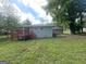 Exterior view of home with a red wooden deck and a spacious grass-covered backyard at 3375 Brenda Ln, Lithia Springs, GA 30122