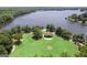 Aerial view of a lakefront property with a building on a grassy lawn, highlighting a serene and scenic location at 101 Sumner Place Ct, Peachtree City, GA 30269