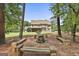 Backyard firepit with built-in seating amidst mature trees at 101 Sumner Place Ct, Peachtree City, GA 30269