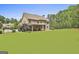 Rear exterior view showcasing a well-manicured lawn, porch, and mature trees at 101 Sumner Place Ct, Peachtree City, GA 30269