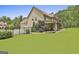 Rear exterior view showcasing a well-manicured lawn, porch, and mature trees at 101 Sumner Place Ct, Peachtree City, GA 30269