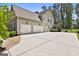 Exterior shot of the home featuring a three car garage and long driveway at 101 Sumner Place Ct, Peachtree City, GA 30269