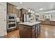 Spacious kitchen boasts a granite island, wooden cabinets, and stainless steel appliances at 101 Sumner Place Ct, Peachtree City, GA 30269