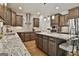 Well-lit kitchen includes granite counters, wooden cabinets, and stainless steel appliances at 101 Sumner Place Ct, Peachtree City, GA 30269
