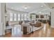 Open-concept living room with hardwood floors, large sofa, fireplace, and abundant natural light at 101 Sumner Place Ct, Peachtree City, GA 30269