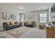Living room features a floral rug, neutral walls, carpet and two sofas with yellow throw pillows at 101 Sumner Place Ct, Peachtree City, GA 30269