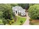 Stately white home with professionally landscaped yard and brick driveway, surrounded by mature trees at 8957 Old Southwick Pass, Johns Creek, GA 30022