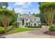 Stately white home with manicured lawn, paved driveway, arched entrance, and lush landscaping at 8957 Old Southwick Pass, Johns Creek, GA 30022