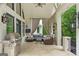 Covered outdoor patio with comfortable seating, grill, TV, and decorative hanging lanterns at 8957 Old Southwick Pass, Johns Creek, GA 30022