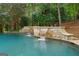 Backyard pool with a rock waterfall feature flows into the pool and offers a peaceful ambiance at 8957 Old Southwick Pass, Johns Creek, GA 30022