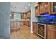 Open-concept bar area featuring wooden cabinets, granite countertops, wine cooler and glass rack at 209 Smokerise Trce, Peachtree City, GA 30269