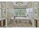 Elegant primary bathroom with a tile-surround soaking tub and a large window with natural light at 209 Smokerise Trce, Peachtree City, GA 30269