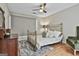 Cozy bedroom features a metal frame bed with throw pillows and gleaming hardwood floors at 209 Smokerise Trce, Peachtree City, GA 30269