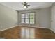Spacious bedroom boasts gleaming hardwood floors, a large window and ceiling fan at 209 Smokerise Trce, Peachtree City, GA 30269