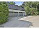 Spacious three-car garage with gray doors and a driveway with plenty of parking at 209 Smokerise Trce, Peachtree City, GA 30269