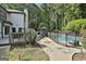 In-ground pool and deck with a fence. Mature trees and greenery in the background at 209 Smokerise Trce, Peachtree City, GA 30269