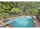 A sparkling in-ground pool with diving board surrounded by a secure fence and mature trees at 209 Smokerise Trce, Peachtree City, GA 30269