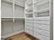 Spacious walk-in closet with hardwood floors and a well-organized system of shelves and drawers at 209 Smokerise Trce, Peachtree City, GA 30269
