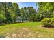 Private backyard features mature trees and a lawn that extends to the shores of the community lake at 255 Mcintosh Estates Dr, Sharpsburg, GA 30277